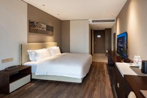 Postel nebo postele na pokoji v ubytování Jian Guo Hotel Yantai Phoenix Building