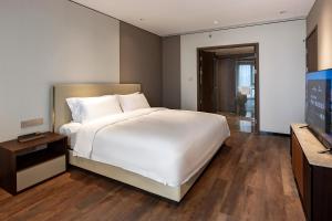 Postel nebo postele na pokoji v ubytování Jian Guo Hotel Yantai Phoenix Building