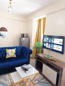 a living room with a blue couch and a table at Pacho luxury homes in Kisumu