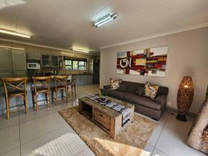 a living room with a couch and a table at Cranes Nest Guest House in Pretoria
