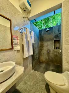 a bathroom with a sink and a toilet and a shower at Seascape Retreats Dhigurah in Dhigurah