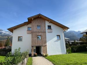 a large white house with a wooden roof at Ferienwohnung Hüttenzauber Schönau in Schönau am Königssee
