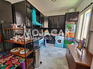 a kitchen with black cabinets and a washer and dryer at Apartment Dreaming with Art - Mojacar Pueblo in Mojácar