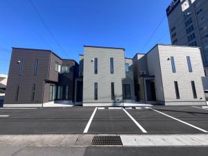 SōshaGUNPAKUMaebashi的城市中一个有三栋建筑的停车场