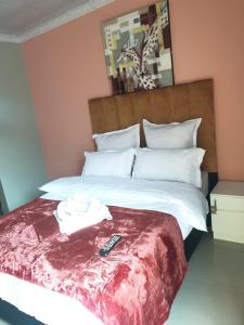 a bedroom with a bed with a remote control on it at PEACE LODGE in Cape Town +16 photos