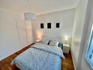 Un dormitorio con una cama con una manta azul. en La kaza, en Vaires-sur-Marne