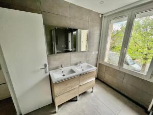 Un baño con lavabo, espejo y ventana. en La kaza, en Vaires-sur-Marne