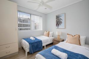 una camera da letto con due letti e una finestra di Oceans at Terrigal a Beachfront Oasis a Terrigal