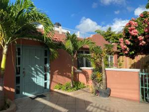 a house with a green door and palm trees at Budgie's 2 Studio in Cozumel