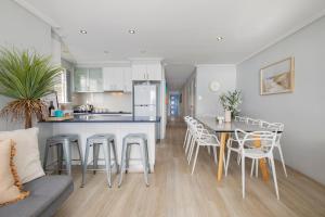 una cucina e un soggiorno con tavolo e sedie di Oceans at Terrigal a Beachfront Oasis a Terrigal