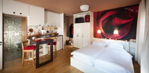 a bedroom with a bed and a desk and a kitchen at City Centre Apartments in Ljubljana