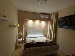 Un dormitorio con una cama grande y un televisor. en Wanderlust maison de voyage, en Catania