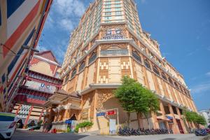 a tall building with a clock on the side of it at Paya Bunga Hotel Terengganu in Kuala Terengganu