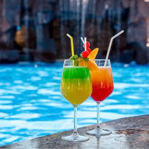 two cocktails in glasses next to a swimming pool at Park Hotel Sankt Peterburg in Plovdiv