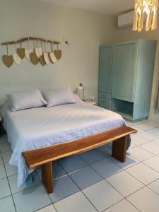 a bedroom with a bed with a wooden bench at Budgie's 2 Studio in Cozumel