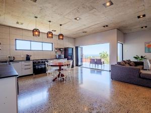 a kitchen and living room with a table and a couch at The Lofts on Manaar in Durban