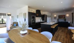 a kitchen and living room with a wooden table at Muramar Beach House in Meirás