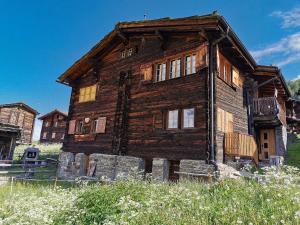 an old wooden house sitting on top of a field at Ferienwohnung Gspon Oberwallis in Staldenried