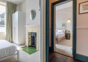 a bedroom with a fireplace and a bed and a mirror at The Emporium - Stylish 2BD in central Winchcombe in Winchcombe