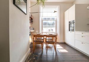 a kitchen with a table and two chairs and a window at The Emporium - Stylish 2BD in central Winchcombe in Winchcombe