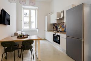a kitchen with a wooden table and a refrigerator at Casa Papaccio Apartment & Spa By Dimorra in Naples