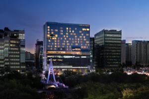 a lit up building in a city at night at Courtyard by Marriott Seoul Pangyo in Seongnam