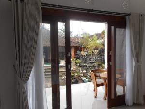 a sliding glass door with a view of a yard at New Lilastana Homestay in Sidemen