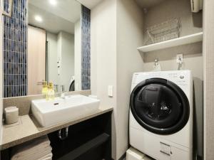 ein Badezimmer mit Waschmaschine und Waschbecken in der Unterkunft MONday Apart Premium UENO OKACHIMACHI in Tokio