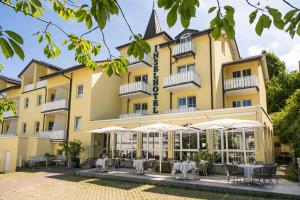 a hotel with tables and chairs in front of a building at Inselhotel Rügen in Göhren