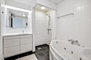 a white bathroom with a tub and a sink at Beautiful Two Story Apartment With Panoramic Views Of Ebeltoft Bay in Ebeltoft +14 photos