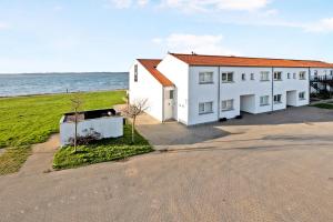 a white building next to a body of water at Beautiful Two Story Apartment With Panoramic Views Of Ebeltoft Bay in Ebeltoft