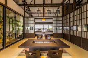 ein Zimmer mit einem Bett und Stühlen in der Unterkunft Nihon Iro in Shizuoka