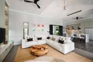 a living room with a white couch and a table at Villa Divano - by Sublime Samui Villas in Choeng Mon Beach
