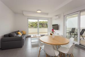 a living room with a table and a couch at Apartments at Villa Frida in Premantura