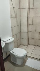 a white bathroom with a toilet and a shower at Pura Vida in San José