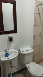 a bathroom with a toilet and a sink and a mirror at Pura Vida in San José