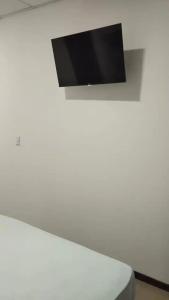a flat screen tv on a white wall at Pura Vida in San José