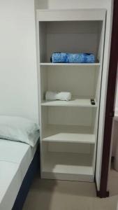 a white book shelf next to a bed at Pura Vida in San José