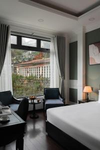 una habitación de hotel con una cama y una ventana grande en The Gate Boutique Hotel Đà Lạt, en Da Lat