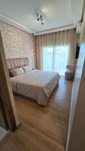 a bedroom with a large bed and a large window at Le doux refuge - à 7 mn de la plage à pieds in Temara +21 photos