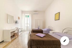 een kamer met 2 bedden, een bureau en een wastafel bij Casa Vacanze Sunshine in Salerno