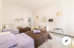 een ziekenhuiskamer met 2 bedden en een televisie bij Casa Vacanze Sunshine in Salerno