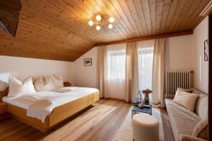 una camera da letto con un letto grande e un divano di Gästehaus Kopp a Stumm
