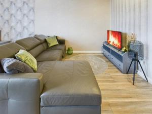 a living room with a couch and a flat screen tv at OtterslebenGartenblick37 - Küche & Garten, bis zu 3 Personen in Magdeburg