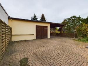 a garage with a brown door and a brick driveway at OtterslebenGartenblick37 - Küche & Garten, bis zu 3 Personen in Magdeburg