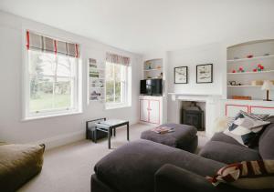 North CerneyにあるTrinity Farmhouse - Stunning House & Gardens!のソファと暖炉のあるリビングルーム