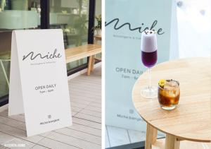 a sign and a glass of wine on a table at LiveZen Bangkok Sukhumvit in Khlong Toei