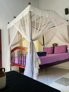 una cama con dosel en una habitación en Berg House Unawatuna, en Galle