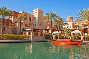 a boat in the water in front of a resort at Lux Escape, Burj Crown Opera View, Near Dubai Mall in Dubai