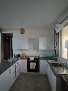 a kitchen with white cabinets and a sink at Daffi giraffi House in Malindi